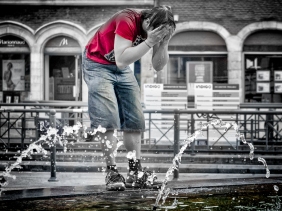 An image of a man washing at a fountain.