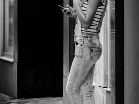 Dungarees - A female smoking and using her mobile phone